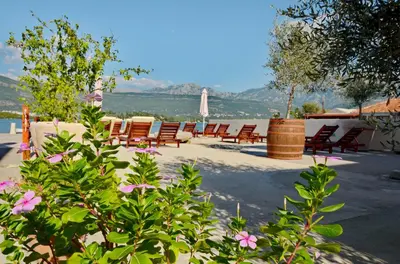 a group of chairs sitting on a patio with flowers at Dubravcevic Residence in Tivat