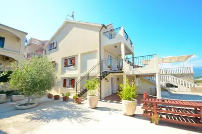 a large white building with a bench in front of it at Dubravcevic Residence in Tivat