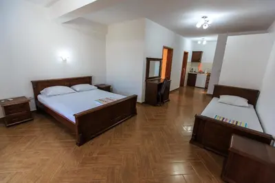 two beds in a room with wooden floors at Apartmani Sejla in Dobra Voda