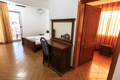 a bedroom with a desk with a mirror and a bed at Apartmani Sejla in Dobra Voda