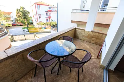 a table and chairs on a balcony with a view of a street at Apartmani Sejla in Dobra Voda