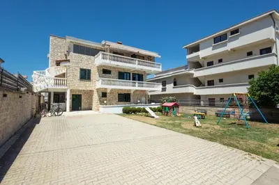 a large building with a playground in front of it at Guest House Pasha in Ulcinj