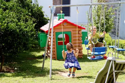 a boy and a little girl playing on a swing at Guest House Pasha in Ulcinj
