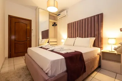 a bedroom with a large bed with a wooden headboard at Guest House Pasha in Ulcinj