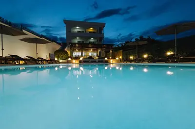 a large swimming pool in front of a building at night at Guest House Pasha in Ulcinj