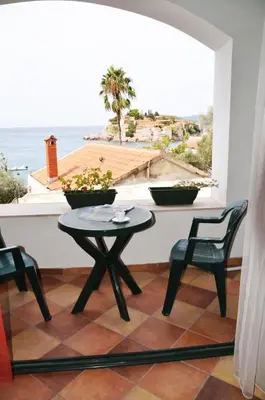 a table and chairs in a room with a view of the ocean at Apartments Secret Garden in Sveti Stefan