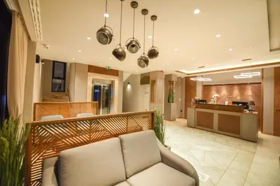 a living room with a couch and a kitchen at Hotel Union in Podgorica
