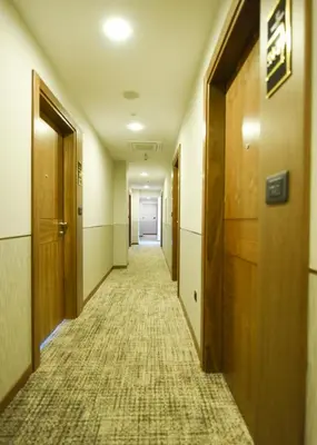 an empty hallway in an office building with wooden doors at Hotel Union in Podgorica