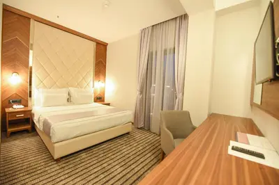a hotel room with a bed and a desk at Hotel Union in Podgorica