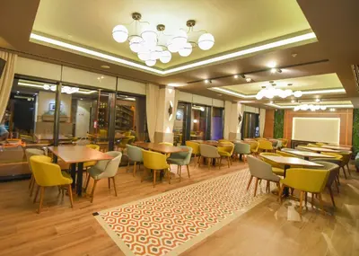 a restaurant with tables and chairs and a chalkboard at Hotel Union in Podgorica