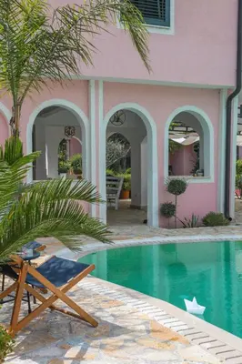 a chair next to a house with a swimming pool at Casa Selimi in Ulcinj