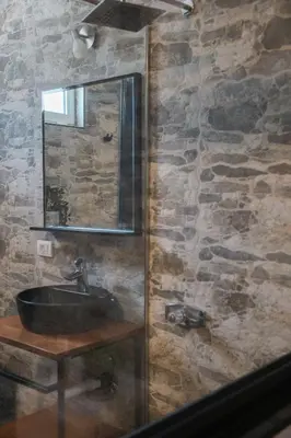 a stone bathroom with a sink and a mirror at Casa Selimi in Ulcinj
