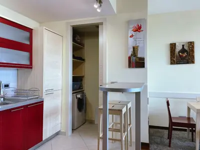 a kitchen with red cabinets and a small table at Oziris apartment in Budva