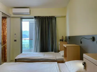 a hotel room with two beds and a window at Oziris apartment in Budva