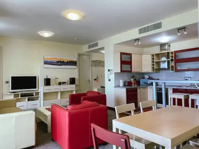 a kitchen and living room with red chairs and a table at Oziris apartment in Budva