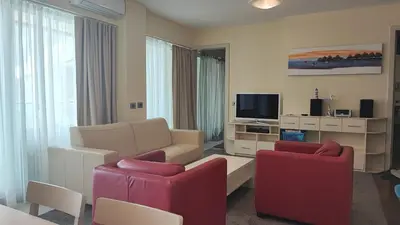 a living room with a couch and two chairs and a tv at Oziris apartment in Budva