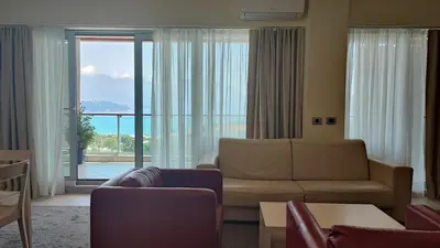a living room with a couch and a large window at Oziris apartment in Budva