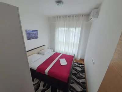 a bedroom with a bed with a red and white blanket at AS Apartments Rafailovici in Rafailovici