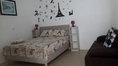 a bedroom with a bed with a comforter and the eiffel tower at Šušanj Ilino APARTMAN in Bar
