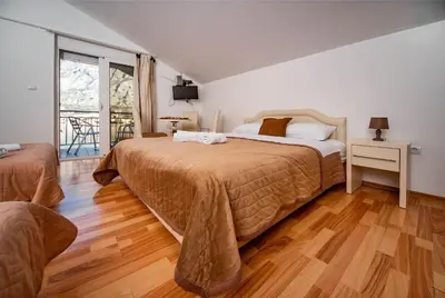 a bedroom with two beds and a large window at Apartments Marković in Kotor