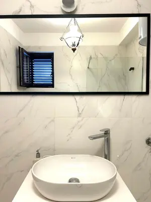 a white bathroom with a sink and a mirror at Apartments Marković in Kotor