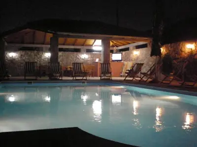 a large swimming pool at night with chairs at Apartments Vila Lazarevic in Tivat
