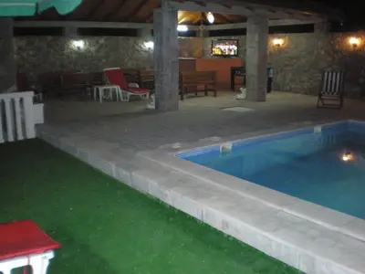 a swimming pool in a backyard at night at Apartments Vila Lazarevic in Tivat