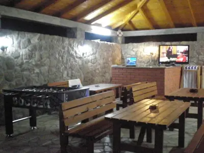 a restaurant with benches and a grill in a room at Apartments Vila Lazarevic in Tivat