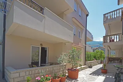 a courtyard of a house with potted plants at Apartmani Kovačević in Kotor