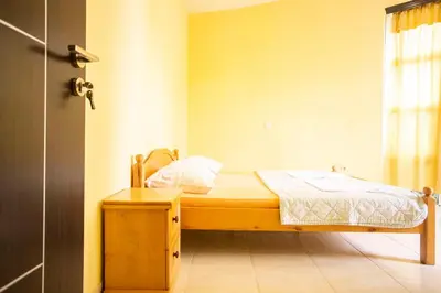 a small bedroom with a wooden bed and a window at Casa Agata in Ulcinj