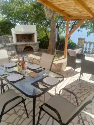 a table and chairs on a patio with a fireplace at Blue Horizon in Dobra Voda