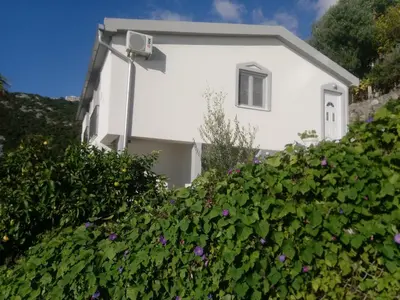 a white house with purple flowers in front of it at Blue Horizon in Dobra Voda