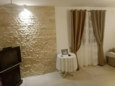 a living room with a table and a wall at Blue Horizon in Dobra Voda