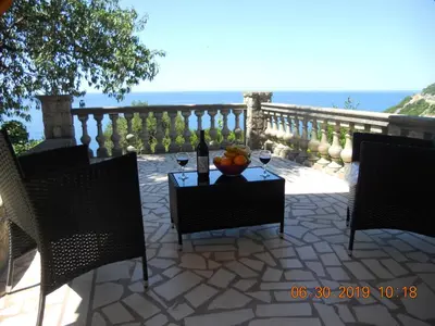 a table with a bottle of wine and a bowl of fruit at Blue Horizon in Dobra Voda