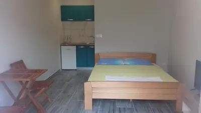 a bedroom with a bed and a table and a chair at Apartments Dakovic in Kotor