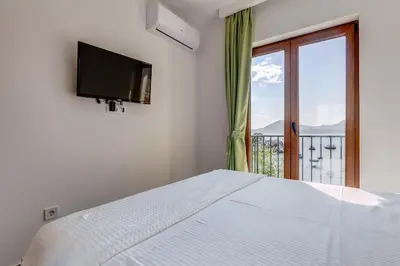a bedroom with a white bed and a window at Mima Apartments in Sveti Stefan
