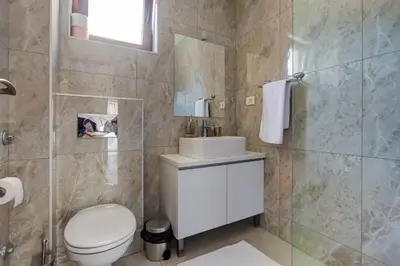 a bathroom with a toilet and a sink and a shower at Mima Apartments in Sveti Stefan