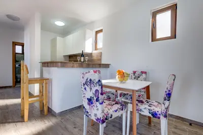 a kitchen and dining room with a table and chairs at Mima Apartments in Sveti Stefan