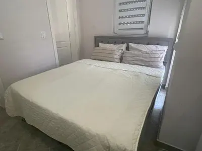a bed with white sheets and pillows in a room at Apartments Jasmina in Utjeha