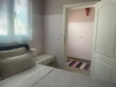 a bedroom with a white bed and a mirror at Apartments Jasmina in Utjeha