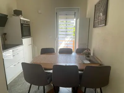 a kitchen with a table and chairs in a room at Apartments Jasmina in Utjeha