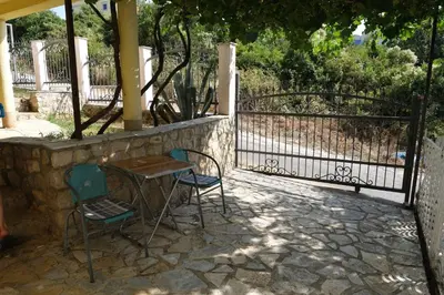 a table and two chairs next to a fence at Apartments Jasmina in Utjeha
