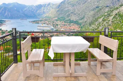 a table and two chairs on a balcony with a view at Apartments Vidikovac Inn in Kotor
