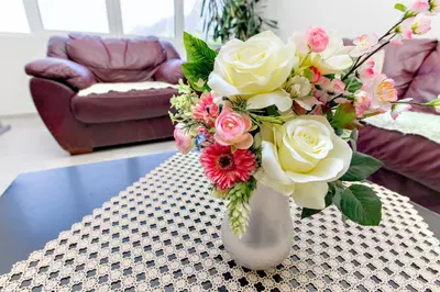 a vase with a bouquet of flowers on a table at Apartments Vidikovac Inn in Kotor