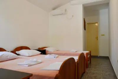 a room with three beds with towels on them at Apartments Stanka in Becici