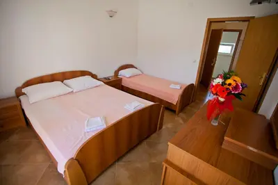a bedroom with two beds and a vase of flowers at Apartments Stanka in Becici