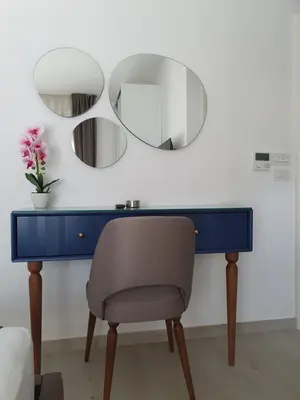 a blue desk with a chair and two mirrors at Apartments Boreta in Budva