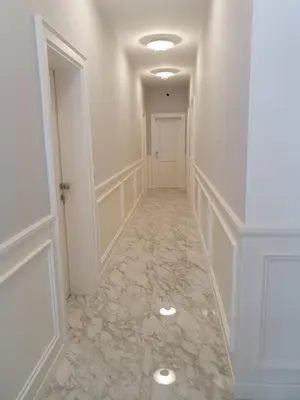 a hallway with white walls and marble flooring at Apartments Boreta in Budva