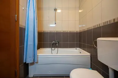 a bathroom with a bath tub and a toilet at Family One bedroom apartment with Panoramic city view in Budva