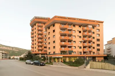 a large apartment building on the side of a street at Family One bedroom apartment with Panoramic city view in Budva